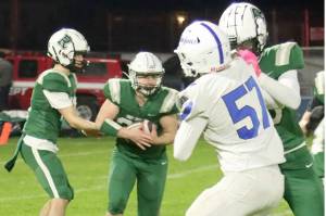 Port Angeles quarterback Blake Sohlberg hands off to running back Dylan Mann on Friday night at Port Angeles Civic Field against Olympic. (Dave Logan/for Peninsula Daily News)