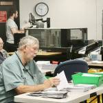 Ray Farrell, left, and Daniel Cain, center, prepare mail-in ballots for counting on Tuesday morning at the Clallam County courthouse in Port Angeles. The tabulating machine can be seen in the background with its operator. Election results, released after press time Tuesday, are online at cmg-northwest2.go-vip.net/peninsuladailynews. Full coverage will appear in Thursdays print edition. (Dave Logan/for Peninsula Daily News)
