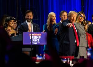 President-elect Donald Trump points to supporters in the audience at his election night gathering in West Palm Beach early Wednesday. Trump rode a promise to smash the American status quo to win the presidency for a second time on Wednesday, surviving a criminal conviction, indictments, an assassins bullet, accusations of authoritarianism and an unprecedented switch of his opponent to complete a remarkable return to power. (Hiroko Masuike/The New York Times)