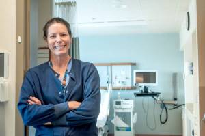 Tracy Ryan, a nurse at Jefferson Healthcare in Port Townsend, stands in front of one of the hospitals maternity ward rooms. (Grace Deng/Washington State Standard)