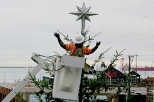 A Port Angeles city worker places a tree topper on the citys Christmas tree, located at the Conrad Dyar Memorial Fountain at the intersection of Laurel and First streets. A holiday street party is scheduled to take place in downtown Port Angeles from noon to 7 p.m. Nov. 30 with the tree lighting scheduled for about 5 p.m. (Emma Maple/Peninsula Daily News)