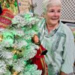Sherry Phillips, chair of the Festival of Trees design committee, stands next to the tree Twelve Days of Christmas, which she designed personally. (Leah Leach/for Peninsula Daily News)