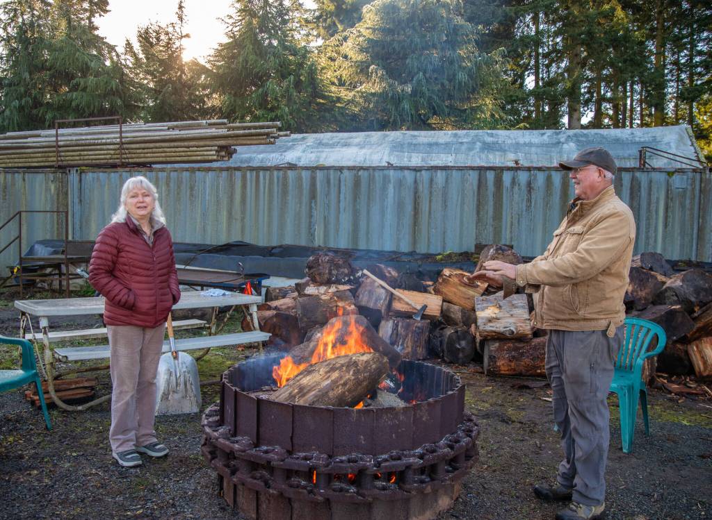 Ann and Steve Johnson talk about some of the stories visitors to the Lazy J Tree Farms Christmas U-Cut have brought them through the years at the fire pit, which is an amenity outside their Christmas barn. (Emily Matthiessen/Olympic Peninsula News Group)