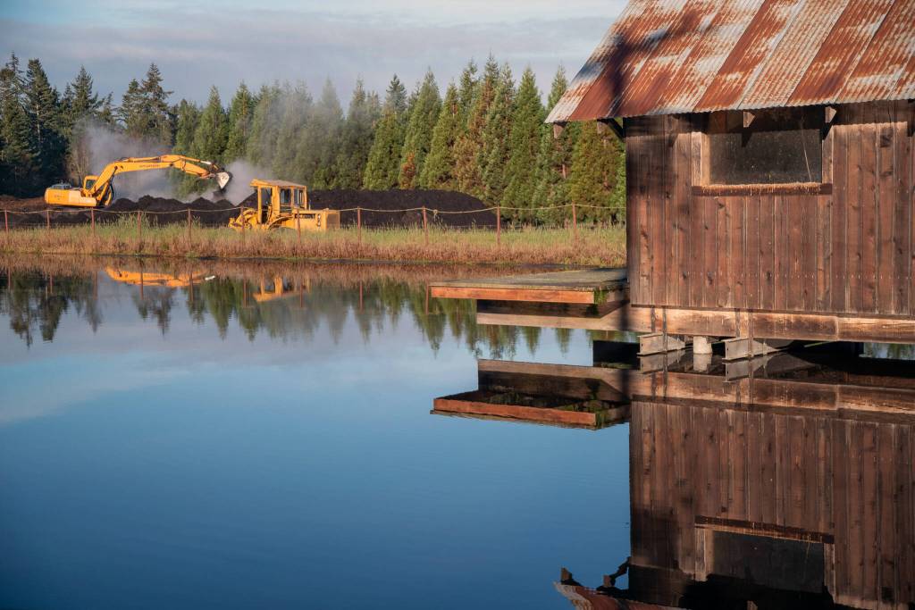 Graham Johnson turns over compost at the Lazy J Tree Farm. (Emily Matthiessen/Olympic Peninsula News Group)