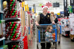 Clallam County Sheriffs Office Chief Criminal Deputy Amy Bundy shops with a child during the Shop with a Hero event on Dec. 7. (Jesse Major)