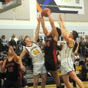 Lonnie Archibald/for Peninsula Daily News
Forks Landon Olson (24) and Brody Lausche challenge Neah Bays Tyler Swan inside for the rebound while Red Devil Daniel Cumming looks on.