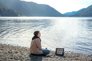 Paranormal investigator Amanda Paulson sits next to a photo of Hallie Illingworth at Lake Crescent, where Illingworths soap-like body was discovered in 1940. Paulson stars in a newly released documentary, The Lady of the Lake, that explores the history of Illingworths death and the possible paranormal presence that has remained since. (Ryan Grulich)