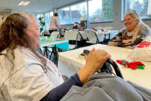 Ellen White Face, left, and Dora Ragland enjoy some conversation after finishing a Christmas dinner prepared by Salvation Army Port Angeles staff and volunteers. The Salvation Army anticipated serving 120-150 people at its annual holiday meal on Tuesday. (Paula Hunt/Peninsula Daily News)