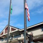 Todd Shay of the Port Angeles Parks and Recreation Department lowers the flags in front of City Hall on Monday to honor Jimmy Carter, the 39th president of the United States who died Sunday at the age of 100. The flags will stay at half-staff until the end of the day Jan. 28 by order of the governor. (Dave Logan/for Peninsula Daily News)