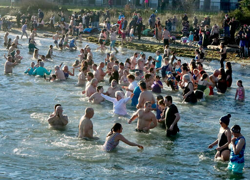 About 150 to 200 people jumped into 49-degree water at Hollywood Beach on Wednesday for the 37th annual Polar Bear Dip. The air temperature was about 39 degrees, so it was a short, brisk dip that they did three times. There was a beach fire to warm the dippers afterward as well as two portable saunas in the parking lot. The event was sponsored by Volunteer Hospice of Clallam County under the leadership of organizer Dan Welden. Hot drinks, tasty muffins and a certificate for participants were available. (Dave Logan/for Peninsula Daily News)