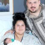 Angel Beadle holds Phoebe Homan, the first baby born on the North Olympic Peninsula in 2025. Father David Homan stands by their side in a room at Olympic Medical Center in Port Angeles. (Dave Logan/for Peninsula Daily News)