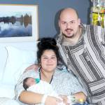 Angel Beadle holds Phoebe Homan, the first baby born on the North Olympic Peninsula in 2025. Father David Homan stands by their side in a room at Olympic Medical Center in Port Angeles. (Dave Logan/for Peninsula Daily News)