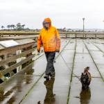 Will Barrett of Port Townsend and his cairn terrier Harris brave the cold and wet weather on Friday to walk around the Marine Science Center pier at Fort Worden State Park. (Steve Mullensky/for Peninsula Daily News)