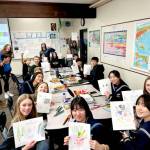 Students from Mutsu City, Japan, and Port Angeles sit in a Stevens Middle School classroom eating lunch before the culture fair on Tuesday. To pass the time, they decided to have a drawing contest between themselves. (Rob Edwards)