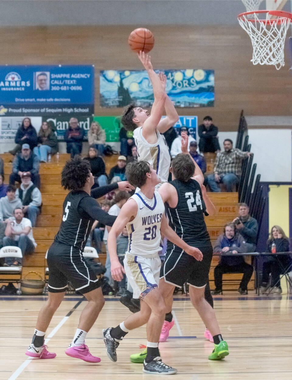 Sequims Charlie Grider goes up for a shot surrounded by North Kitsap defenders Friday as teammate Mason Rapelje (20) is in on the play. The Wolves beat the Vikings 74-46. (Emily Matthiessen/Olympic Peninsula News Group)