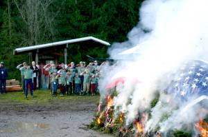 Members of Trail Life USA, a boys Christian adventure organization, salute the burning retired flags and holiday wreaths from veterans graves. This joint flag retirement and wreath burning ceremony took place Saturday at the Bekkevar farm in Blyn. (Emma Maple/Peninsula Daily News)