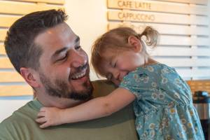 Rod Dirks enjoys affection from his 2-year-old daughter Maeli, who expresses confidence that doctors will heal her dads cancer. (Emily Matthiessen/Olympic Peninsula News Group)