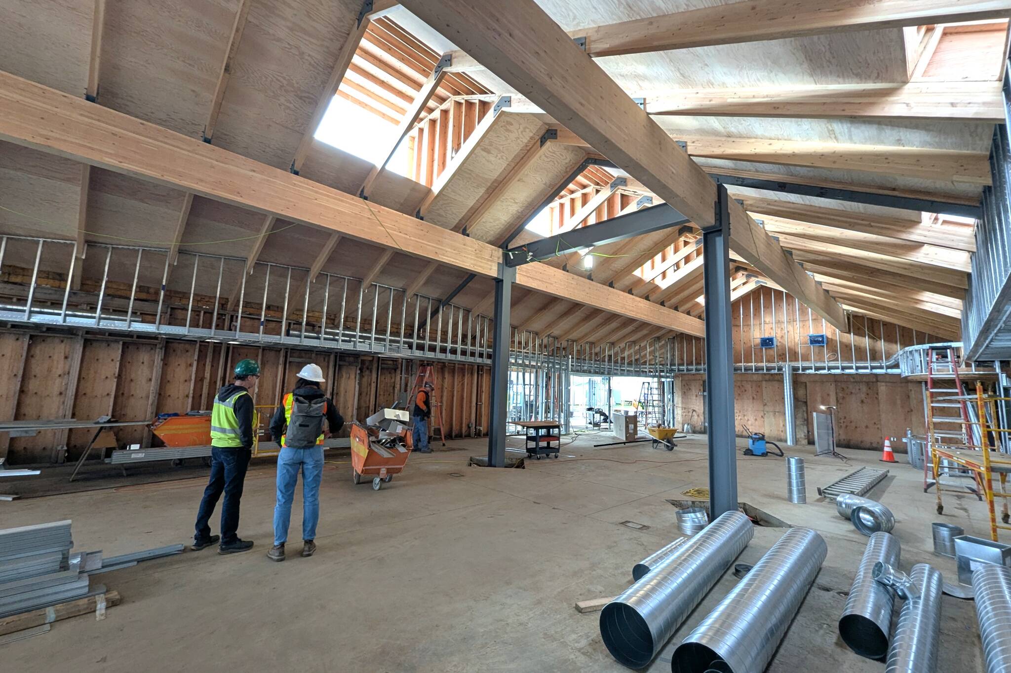 At a recent site visit, North Olympic Library System Facilities Manager Brian Phillips and SHKS Architect Pia Westen examine construction progress at the Sequim Library as its being renovated and expanded. NOLS leaders anticipate reopening the facility in June. (North Olympic Library System)