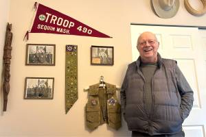 Matthew Nash / Olympic Peninsula News Group
Rick Godfrey stands with his Boy Scouts of America achievements on his offices wall, including his merit badges and Troop 490 photos. In 1950, he was the youngest scout in the state to earn his Eagle Scout, the highest rank in scouting. The troop celebrated 100 years at a special dinner on Saturday at the Sequim Masonic Lodge.