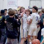 Sequim students storm the court and celebreate with Ethan Melnick (0) and Solomon Sheppard (3) after the Wolves beat Bremerton 66-61 on Monday night to earn a share of the Olympic League boys basketball championship. Sequim and Bremerton will play in Poulsbo tonight in a rubber match to determine playoff seeding. (Emily Mathiessen/Olympic Peninsula News Group)