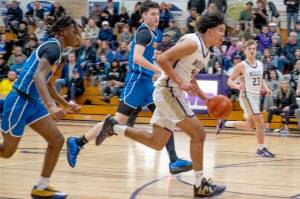 Sequim's Jericho Julmist drives to the basket against Bremerton in Sequim on Monday night. In on the play is Sequim's Zeke Schmadeke. Sequim won 66-61 to earn a share of the Olympic League title. (Emily Mathiessen/Olympic Peninsula News Group)