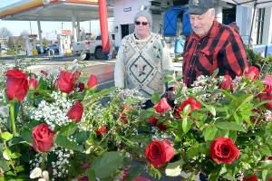Fred Rix of Port Angeles, right, looks over floral arrangements with Ann ONeill, an employee of Angel Crest Gardens of Port Angeles at a temporary stand at First and Race streets in Port Angeles on Valentines Day. Rix said he wanted roses for his wife, Wendy Rix, for their 55th wedding anniversary. (Keith Thorpe/Peninsula Daily News)