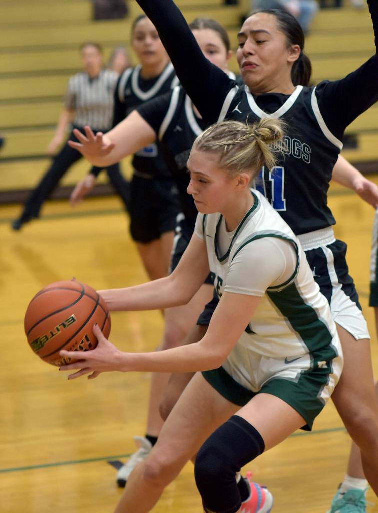 KEITH THORPE/PENINSULA DAILY NEWS Teanna Clark of Port Angeles, front, receives a pass as North Masons Natalya Garcia puts up a block on Tuesday evening in Port Angeles.
