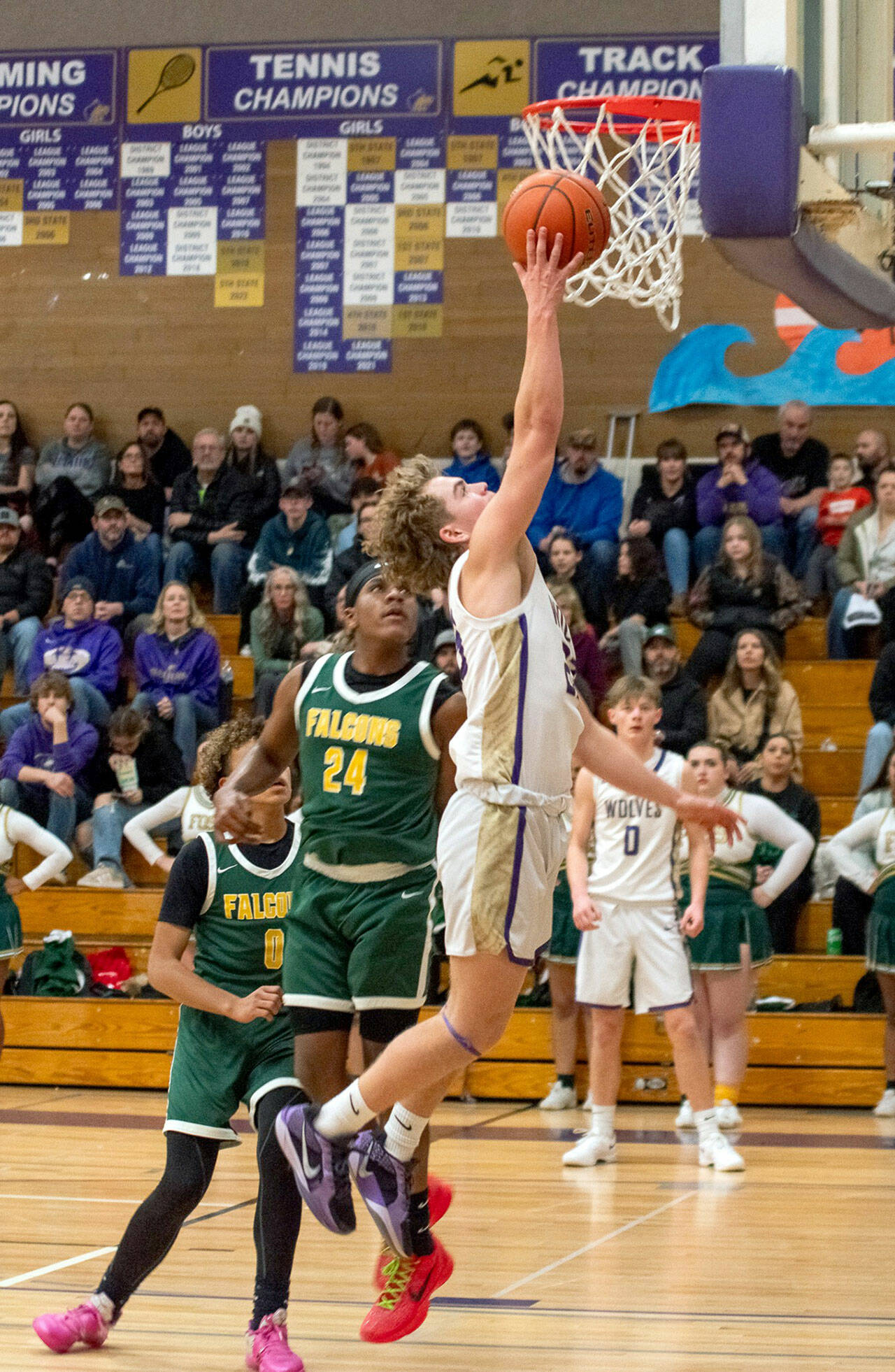 Emily Matthiessen/Olympic Peninsula News Group Sequims Zeke Schmadeke puts up a layup while defended by Foss Zaire Stubblefield during the Wolves 76-50 Class 2A West Central District Boys Basketball Tournament victory Wednesday at Rick Kaps Gym.