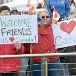 John and Deb Wallace of Sequim hold welcome signs for Canadian passengers disembarking the Coho ferry upon the resumption of daily service between Victoria and Port Angeles on Thursday. (Keith Thorpe/Peninsula Daily News)