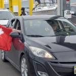 A passenger in a car arriving by ferry in Port Angeles on Thursday waves a Canada shirt as it clears U.S. customs in Port Angeles. (Keith Thorpe/Peninsula Daily News)
