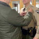 Retired Sheriff Joe Nole pins interim Sheriff Andy Pernsteiners new badge on, following his appointment at the Jefferson County Courthouse.
