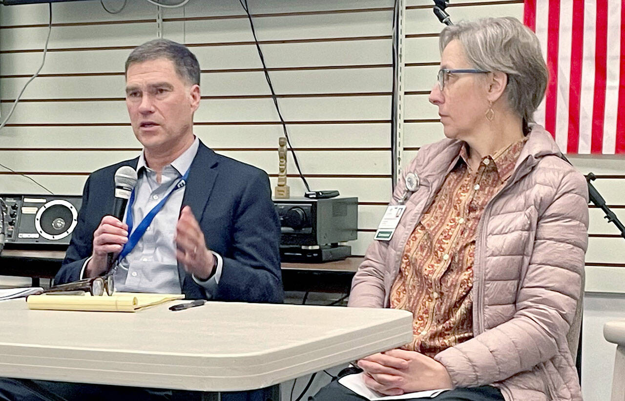 Olympic Medical Center CEO Darryl Wolfe, left, and board President Ann Henninger present information and answer questions about the hospitals exploration of a possible partnership with another health care system at a forum held by the Clallam County Democrats. Aligning with another organization could help address OMCs financial challenges and meet community care needs, Wolfe said. (Paula Hunt/Peninsula Daily News)