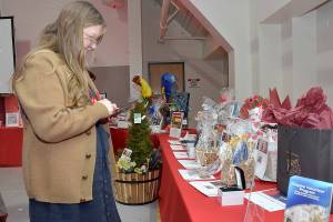 Sonja Elofson of Port Angeles examines a table of auction items during Fridays Red, Set Go! heart healthy luncheon at Vern Burton Community Center in Port Angeles. The event, hosted by the Olympic Medical Center Foundation and presented by Virginia Mason Franciscan Health, was designed to raise funds for the Olympic Medical Center Heart Center. (Keith Thorpe/Peninsula Daily News)