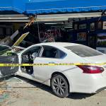 Port Angeles police officers and firefighters responded Friday after a car when into a building in the 600 block of East Front Street. Traffic was disrupted until the vehicle could be cleared from the scene, police said. (Port Angeles Police Department)