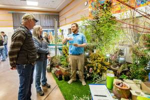 Stewart Cockburn from New Dungeness Nursery in Sequim explains landscaping ideas to Steve Sodorff and his wife Patti of Port Townsend while attending the annual Jefferson County Home Builders Association Home Show on Saturday at Blue Heron Middle School. (Steve Mullensky/for Peninsula Daily News)