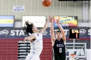 Sequims Ethan Melnick (0) shoots a three over Dalton Stevens outstretched hand during Sequims 69-59 loss to Mark Morris in a Round of 12 game at the 2A state tournament at the Yakima Valley SunDome on Wednesday. (Dylan Wilhelm /Daily Chronicle)