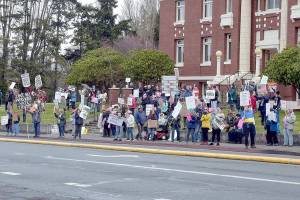 Part of a crowd of nearly 200 people gathers in front of the Clallam County Courthouse in Port Angeles on Saturday for International Womens Day. The gathering was one of numerous events around the world honoring women and their contributions to global society. (Keith Thorpe/Peninsula Daily News)