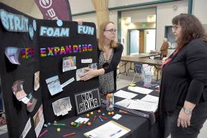 Nicole Merrigan, owner of Strait Up Foam Fun, left, talks with Carol Koenig of Sequim during Thursdays Clallam County Job Fair at Vern Burton Community Center in Port Angeles. About two dozen prospective employers took part in the event, hosted by the Greater Port Angeles Chamber of Commerce. (Keith Thorpe/Peninsula Daily News)