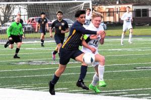 Forks' Estevan Ramos (2) competes with Roughrider Matthew Miller (10) on the turf of Spartan Stadium where Port Angeles defeated Forks 2 to 0.  Photo by Lonnie Archibald.