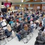 An overflow audience in the Pirate Union Building at Peninsula Collage watches U.S. Rep. Emily Randall, D-Bremerton, speak on video screens on Saturday at Peninsula College in Port Angeles. (Keith Thorpe/Peninsula Daily News)