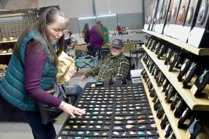 Jeannine Vaughn of Carlsborg looks a gems and jewelry at a display table operated by Steve Morgan of Joyce-based Lil Log Cabin Creations on Saturday at the Clallam County Rock, Gem and Jewelry Show at Vern Burton Community Center in Port Angeles. The show, hosted by the Clallam County Gem & Mineral Association, brought together rock enthusiasts with vendor booths and demonstrations highlighting the hobby. (Keith Thorpe/Peninsula Daily News)