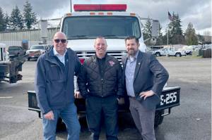 Port Executive Director Paul Jarkiewicz, left, City Fire Chief Derrell Sharp and Port Angeles City Manager Nathan West, right, pose in front of the citys newly purchased wildland urban interface fire engine. (City of Port Angeles)