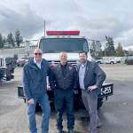 Port Executive Director Paul Jarkiewicz, left, City Fire Chief Derrell Sharp and Port Angeles City Manager Nathan West, right, pose in front of the citys newly purchased wildland urban interface fire engine. (City of Port Angeles)