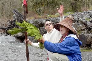 Lummi Nation member Freddie Lane, whose tribal name is Sul Ka Dub, left, and tribal elder Richard Solomon, known as Hutch Ak Wilton, kneel along the banks of the Elwha River in Olympic National Park on Friday to ceremonially ask permission to be at the river in preparation for World Water Day festivities in Port Angeles. Lane, along with members of the Lower Elwha Klallam Tribe, will take part in an opening ceremony at 11 a.m. today at Hollywood Beach, followed by an interfaith water blessing at nearby Pebble Beach Park. Other World Water Day activities include guided nature hikes, environmentally themed films at the Little Theater at Peninsula College and a performance by Grammy Award-winning indigenous artist Star Nayea. (Keith Thorpe/Peninsula Daily News)