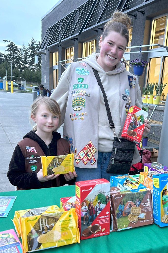 Girl Scouts Malta Bushy and Skylar Krzyworz sell cookies on March 7 for Troop 45181. They will use sales for various trips, including an overnight stay at the Point Defiance Zoo and Aquarium in April. Krzyworz has saved her cookie sales for three years for a trip to Greece and Italy this summer. (Matthew Nash/Olympic Peninsula News Group)