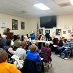 Kathy Cruz/Olympic Peninsula News Group
Susan Fisch, standing, chair of the Clallam County Charter Review Commission, addresses a crowd of residents who packed the meeting room at KSQM FM (91.5) last month for the first of several town hall events. Speakers were allowed up to three minutes to share their views about issues related to the charter that they consider most important.
