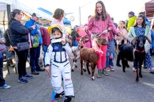 Heath Wade, 5, leads the goat parade to open the 37th annual Port Townsend Farmers Market on Saturday in the uptown neighborhood. Behind are goat wranglers Lindsey Kotzebue and Amber Langley of Port Townsend. (Steve Mullensky/for Peninsula Daily News)