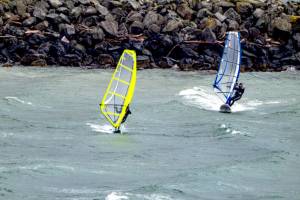 A pair of wind surfers take off from the breakwater at Port Townsend Marina in an apparent race across the bay on Tuesday. (Steve Mullensky/for Peninsula Daily News)