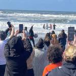 Four Quileute Tribal School students take a salmon offering into the ocean as part of the annual Welcoming the Whales ceremony at First Beach in La Push on Friday. (Christi Baron/Olympic Peninsula News Group)