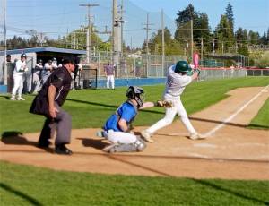 Port Angeles' Trae Hanan hits a single to begin a big rally in the sixth inning against Olympic on Tuesday. Port Angeles won 5-2, then dropped an eight-inning game 6-5 to Bainbridge later in the night. (Pierre LaBossiere/for Peninsula Daily News)